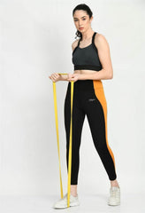 Waylene Black and Mustard Gym Tights with color block design, shown with a model holding a resistance band