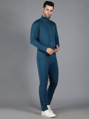 Model posing with hand in pocket, wearing Waylene's teal slimfit sweatshirt and trackpants, styled with white sneakers