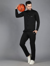 Waylene's slimfit training sweatshirt and trackpant set in black, featuring a male model holding a basketball. The model is in a dynamic pose with the basketball resting on his shoulder, showcasing the sleek design and comfortable fit of the outfit.