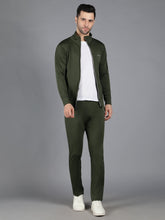 Waylene's male model in olive green slimfit training sweatshirt and track pant set, standing with hands in pockets, facing forward in a neutral pose on a grey background.