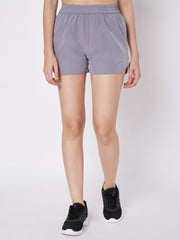 Model standing frontally showcasing Waylene's grey polyester shorts, emphasizing the comfortable waistband and smooth texture, paired with black athletic shoes for a complete workout look.