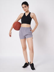 Waylene's grey polyester shorts for women, featuring a model in a sporty pose holding a basketball, paired with a black crop top and black sneakers, highlighting the shorts' casual fit and lightweight design.