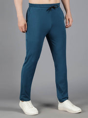 Waylene's teal blue solid trackpant displayed in a standing pose with hands slightly pushed back, emphasizing the slim fit design.