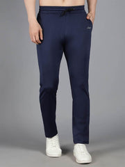 Waylene's navy blue solid trackpant modeled by a man standing straight with hands at his sides, paired with white sneakers