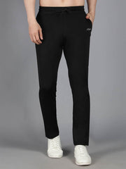 Waylene's black solid trackpant featuring a straight-fit design, elastic waistband with drawstring, and Waylene logo on the left thigh, modeled by a man standing frontally against a gray background with hands in pockets.