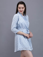 Young woman in Waylene's light blue polka dot robe with a tie waist, standing and looking slightly to the side, showcasing the flowing fit and mid-thigh length.
