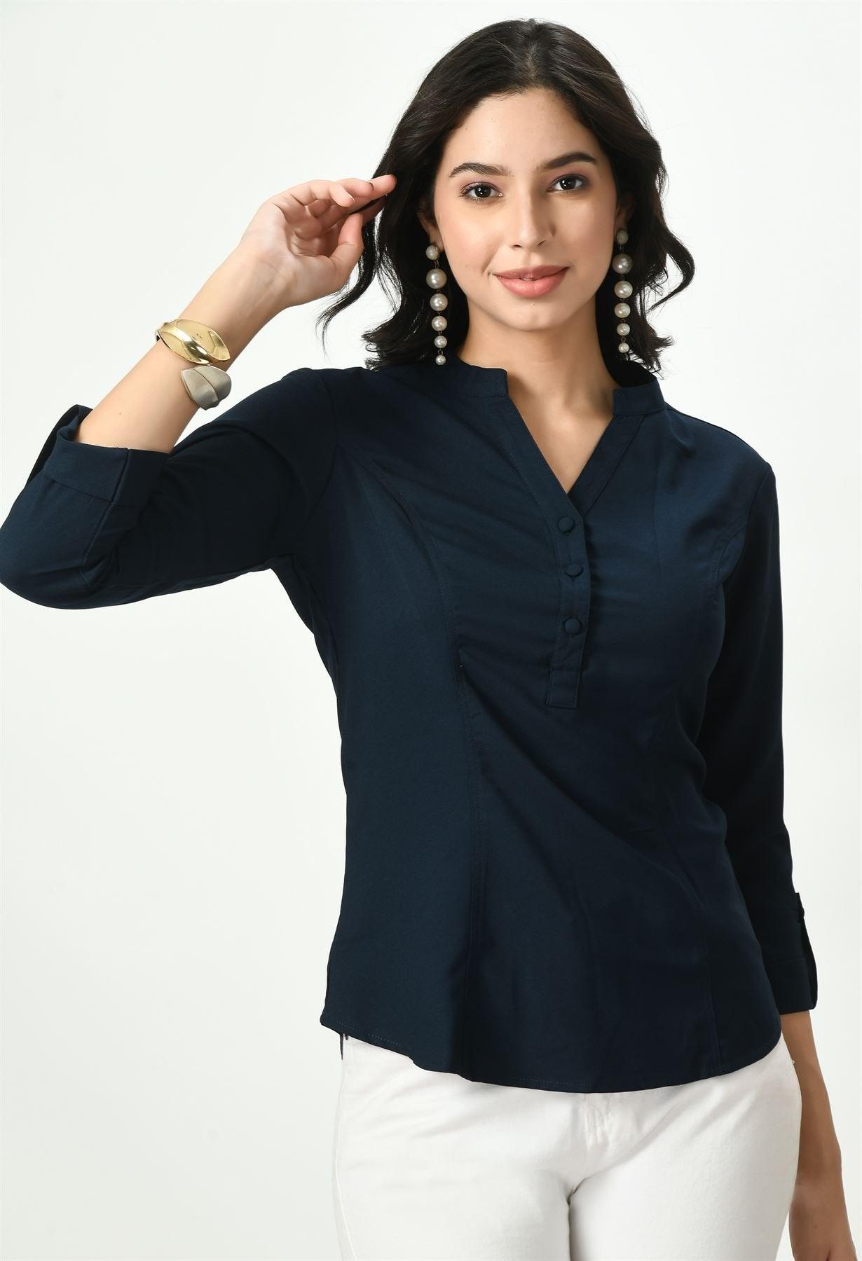 Waylene's dark navy blue top featuring a sophisticated V-neckline and a button-up front, modeled by a woman in a playful pose with one hand touching her hair, paired with white trousers and a gold watch.