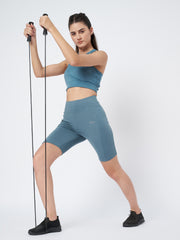 Waylene's teal sports shorts on a female model using resistance bands, featuring a snug fit and mid-thigh length, ideal for active workouts.