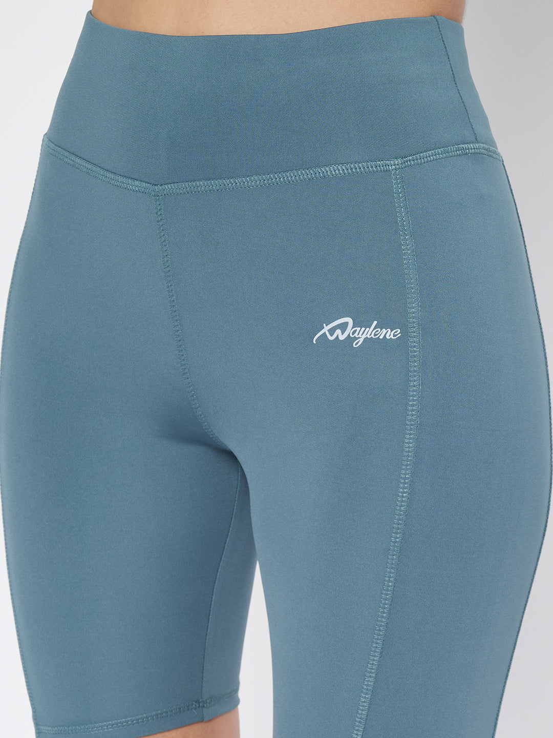 Close-up on the midsection of Waylene's teal sports shorts, showing the detailed stitching and logo placement for a stylish athletic look.