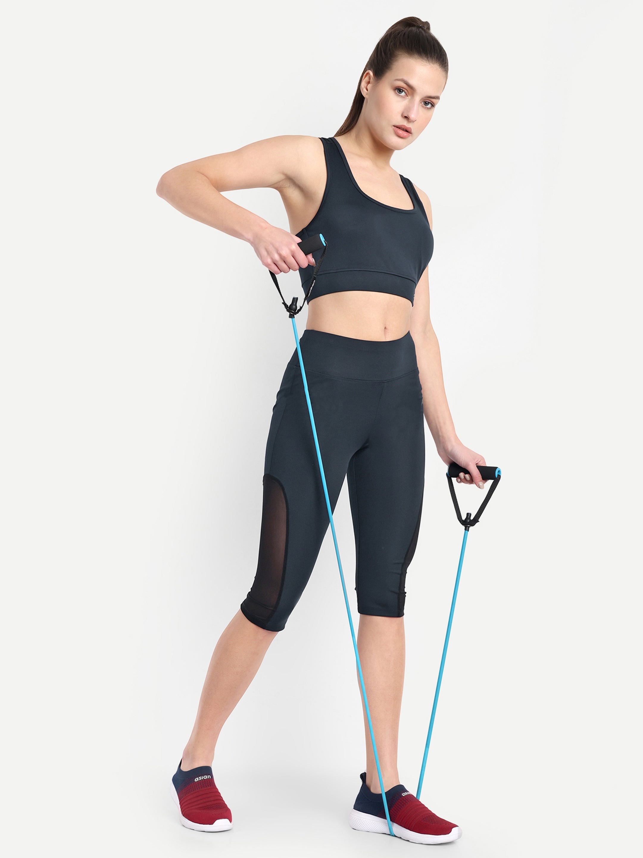 Woman is doing gym workout in Waylene navy blue high-waisted sports capris with mesh panels and sports bra.