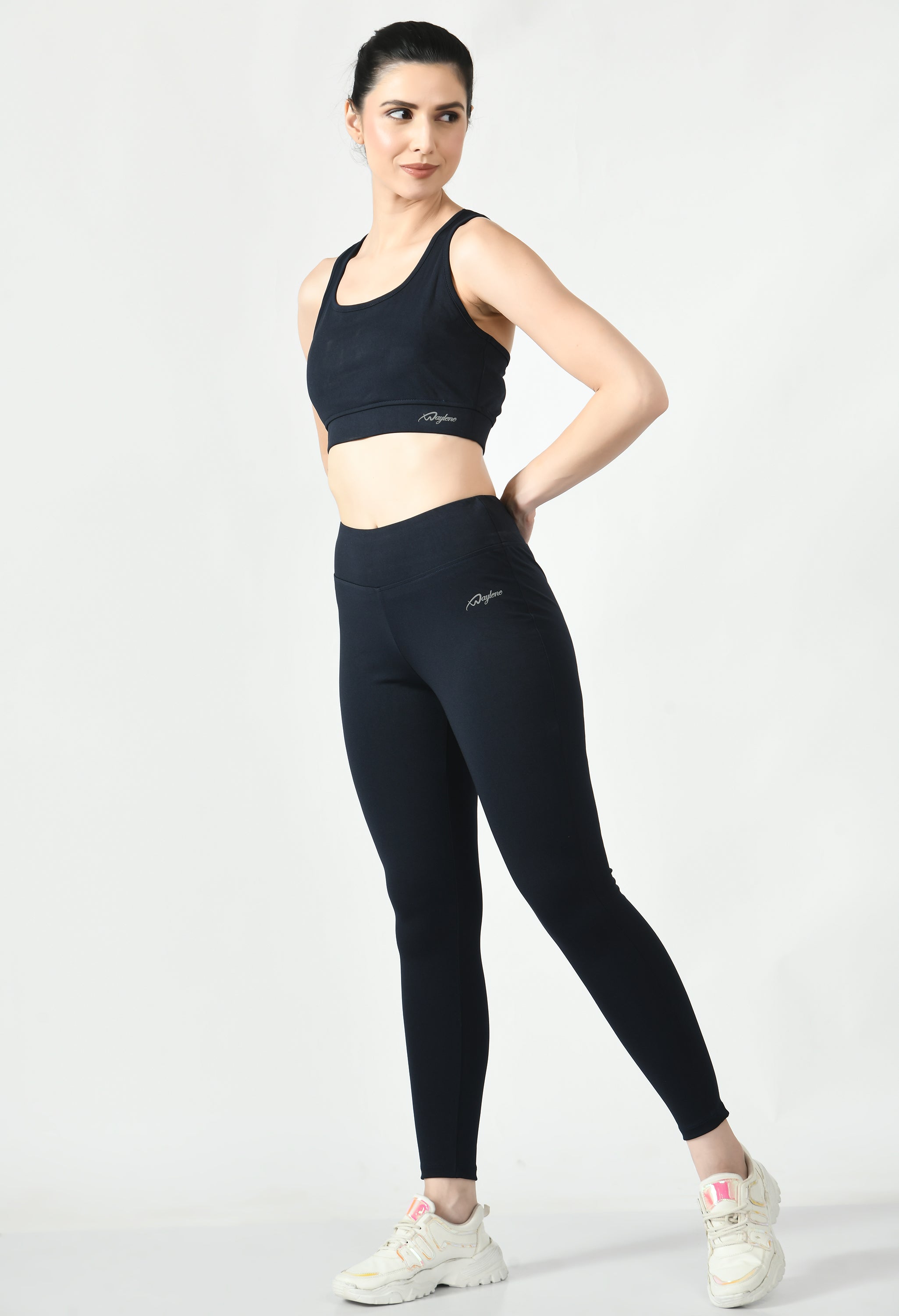 Fitness model showcasing the comfortable fit and support of Waylene's black sports bra and black sports leggings front view