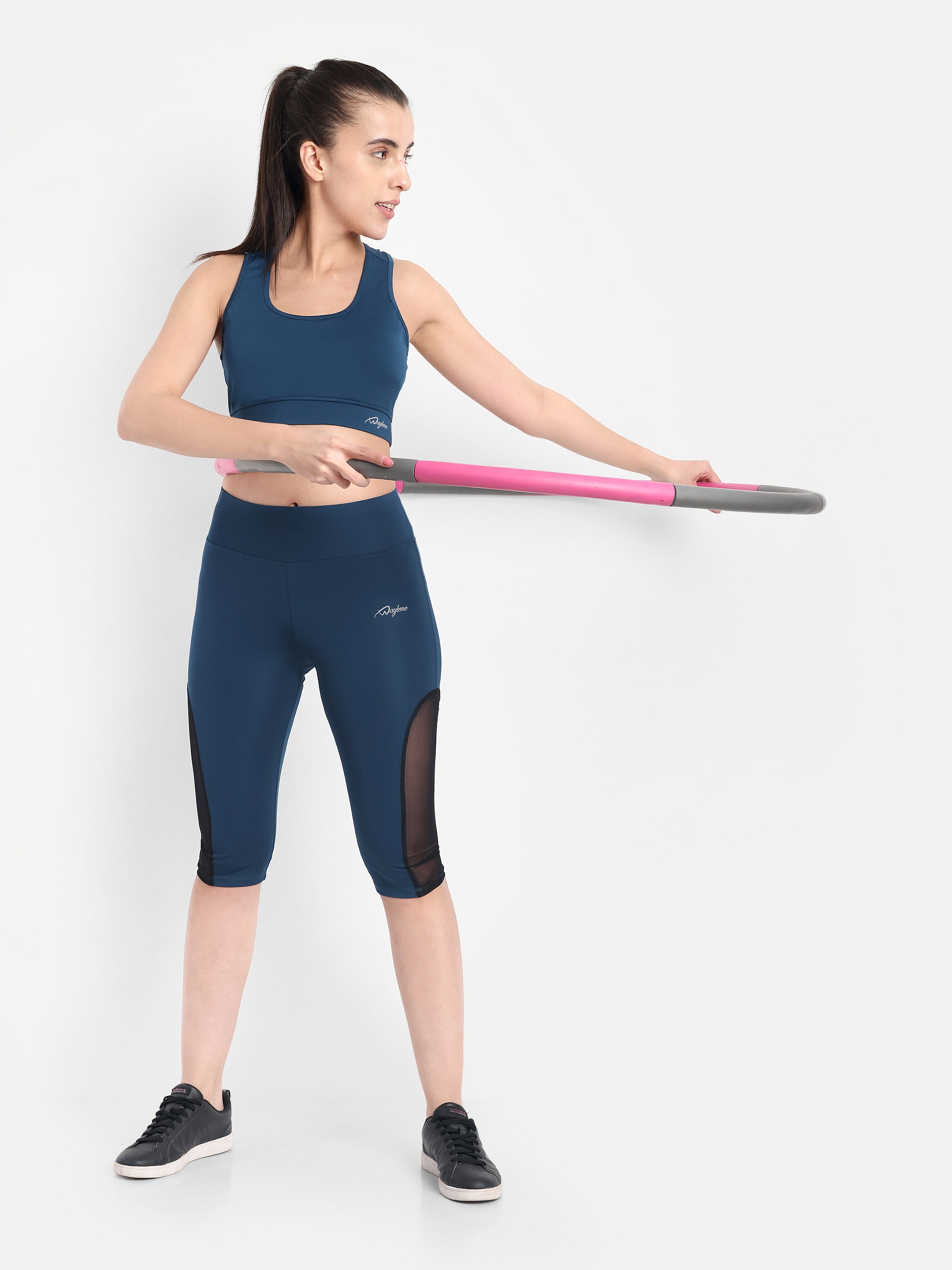 Woman performing gym workout in Waylene light blue high-waisted sports capris with mesh panels.