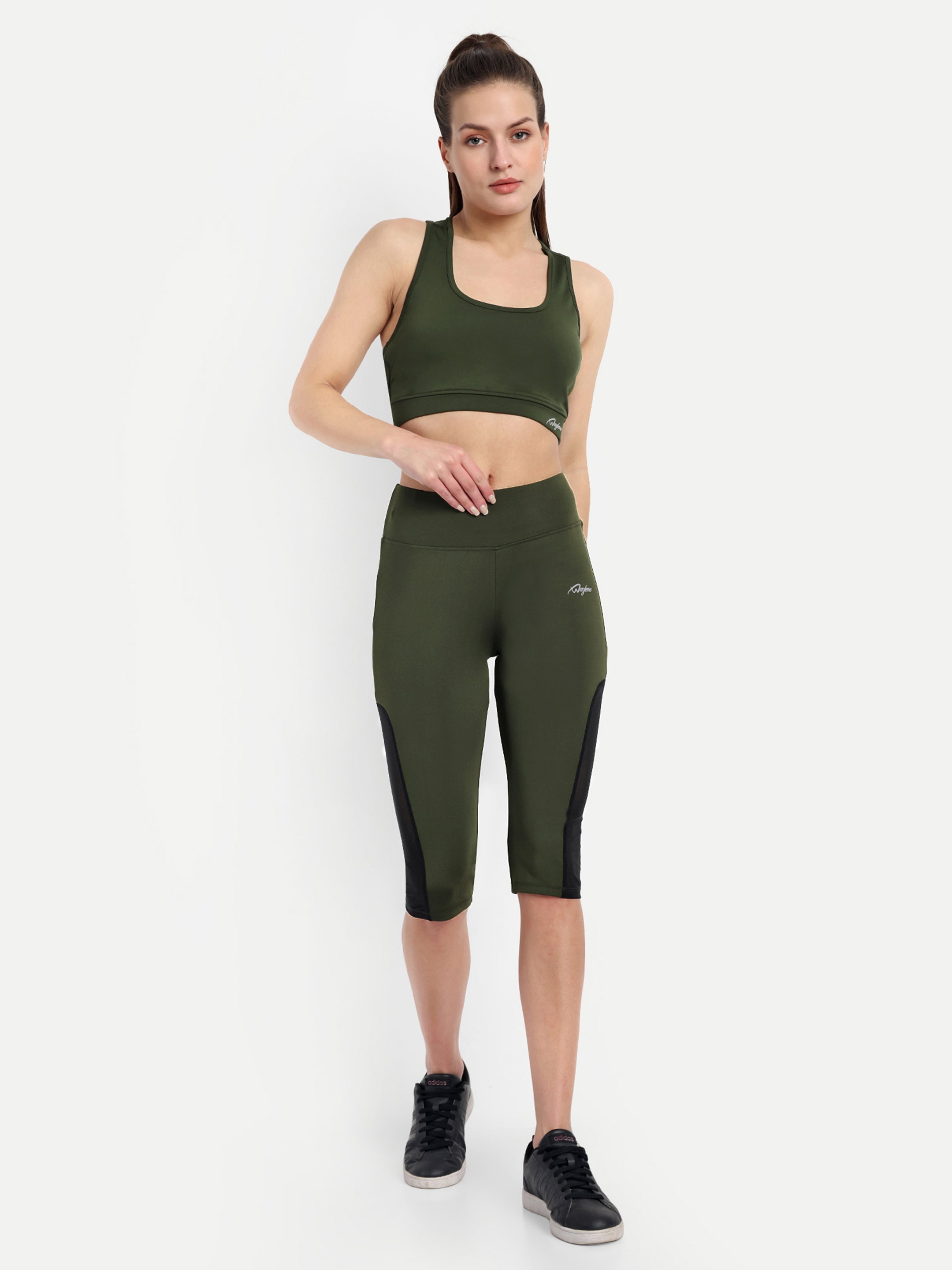 Woman in Waylene olive green high-waisted sports capris with mesh panels and sports bra