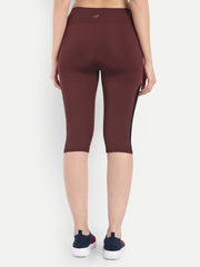 Woman in Waylene maroon (wine) high-waisted sports capris with mesh panels back view