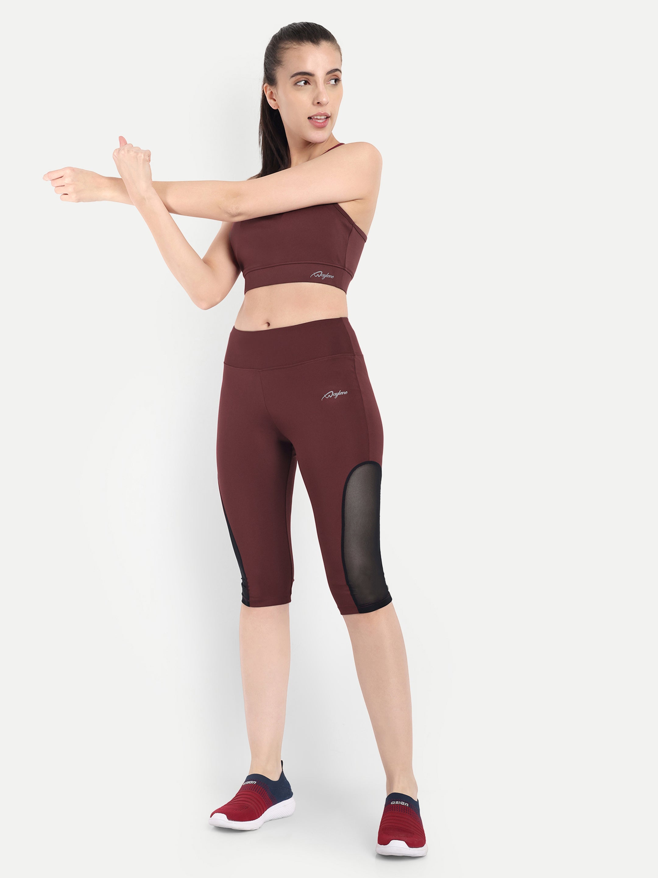 Woman in Waylene maroon (wine) high-waisted sports capris with mesh panels and sports bra