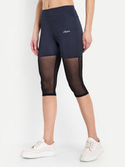 Woman wearing  Waylene navy blue high-waisted capri leggings with rounded mesh panels – side view