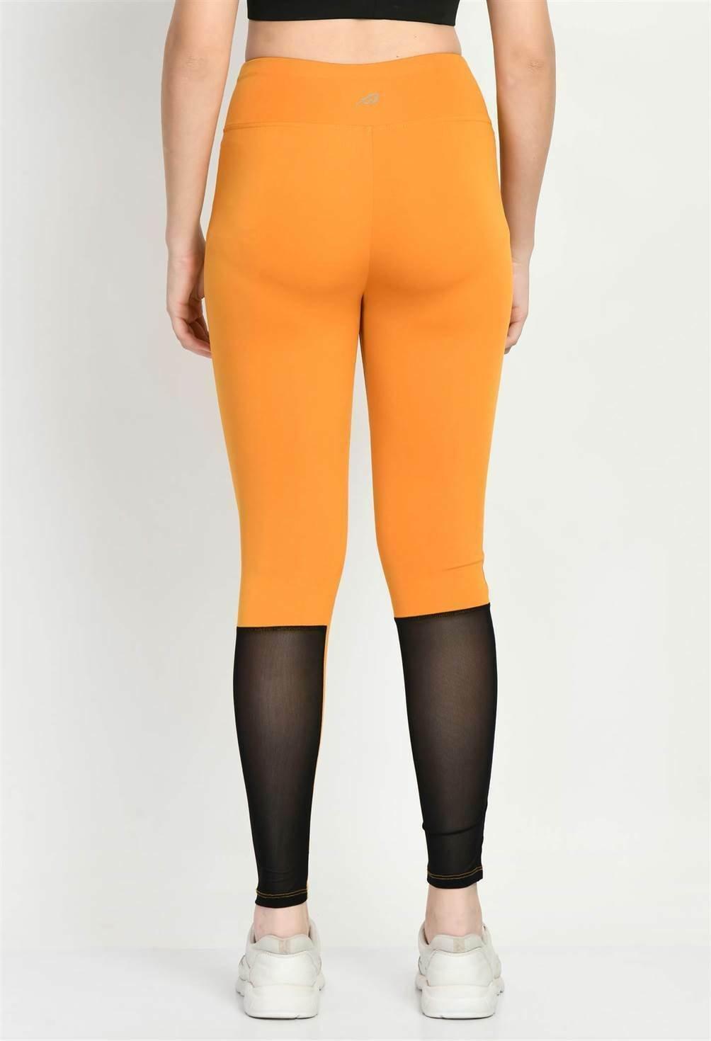 Rear view of Waylene's mustard color block tights, model showing the supportive high waistband and color contrast
