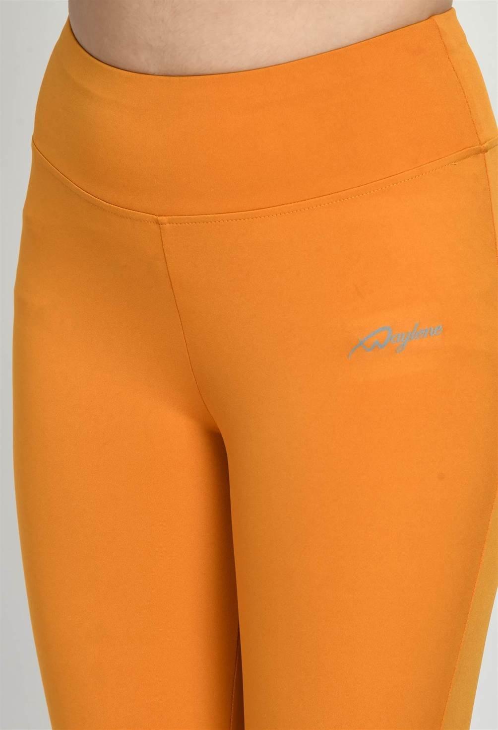 Close-up of Waylene's mustard tights featuring the signature logo, highlighting the smooth texture and detailed stitching