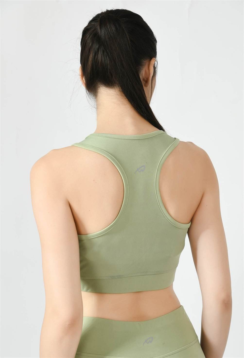 Close-up of Waylene light green (pista green) sports bra showing racerback design and stretchable straps - back view