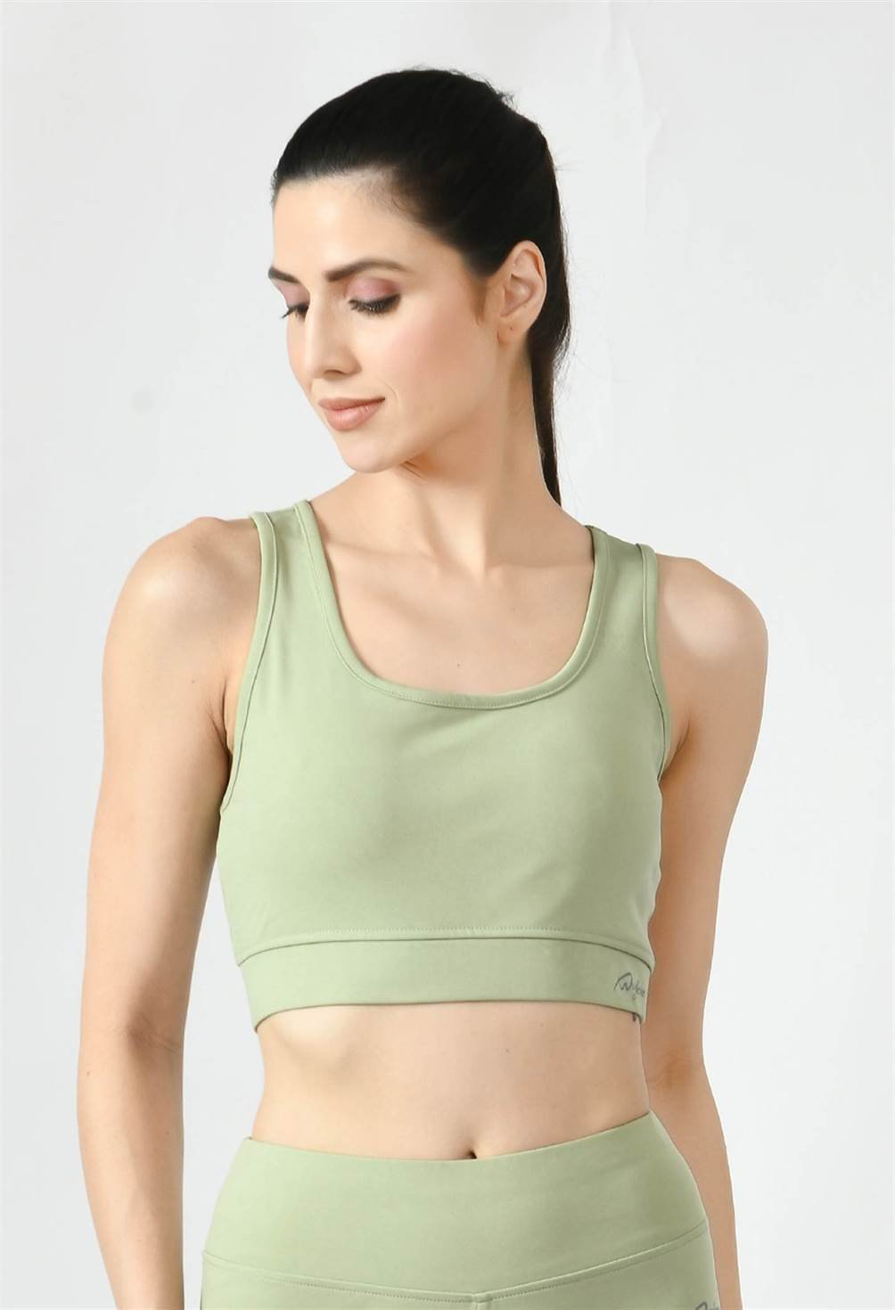 Close-up of Waylene light green (pista green) sports bra showing racerback design and stretchable straps - front view