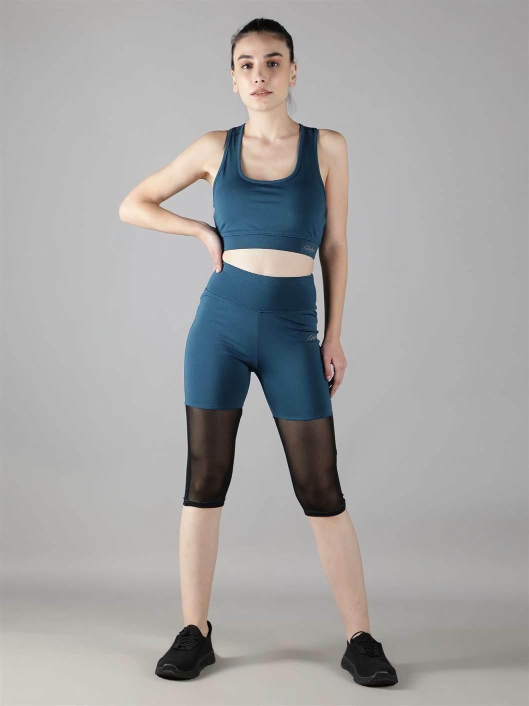 Woman performing yoga poses in Waylene light blue (teal) high-waisted sports capris with rounded mesh panels and sports bra