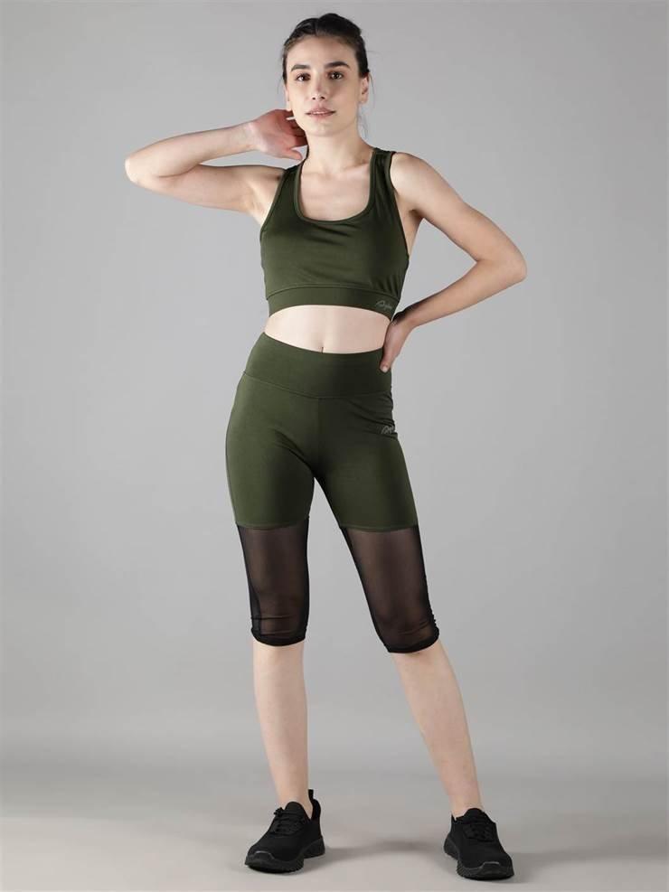 Woman practicing yoga in Waylene olive green high-waisted capri leggings with rounded mesh panels and sports bra