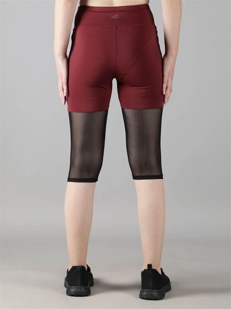 Woman wearing Waylene maroon (wine) high-waisted capri leggings with rounded mesh panels – back view