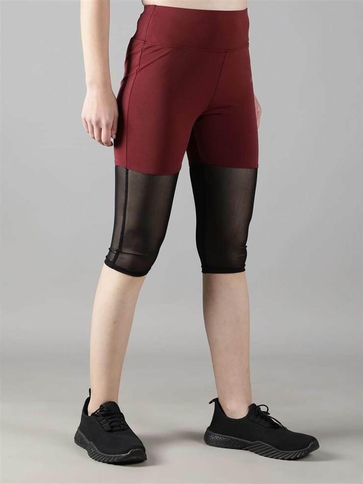 Woman wearing Waylene maroon (wine) high-waisted capri leggings with rounded mesh panels – side view 2