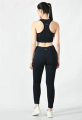 Model showcasing the comfortable fit of Waylene's navy blue sports bra with navy blue sports leggings back view